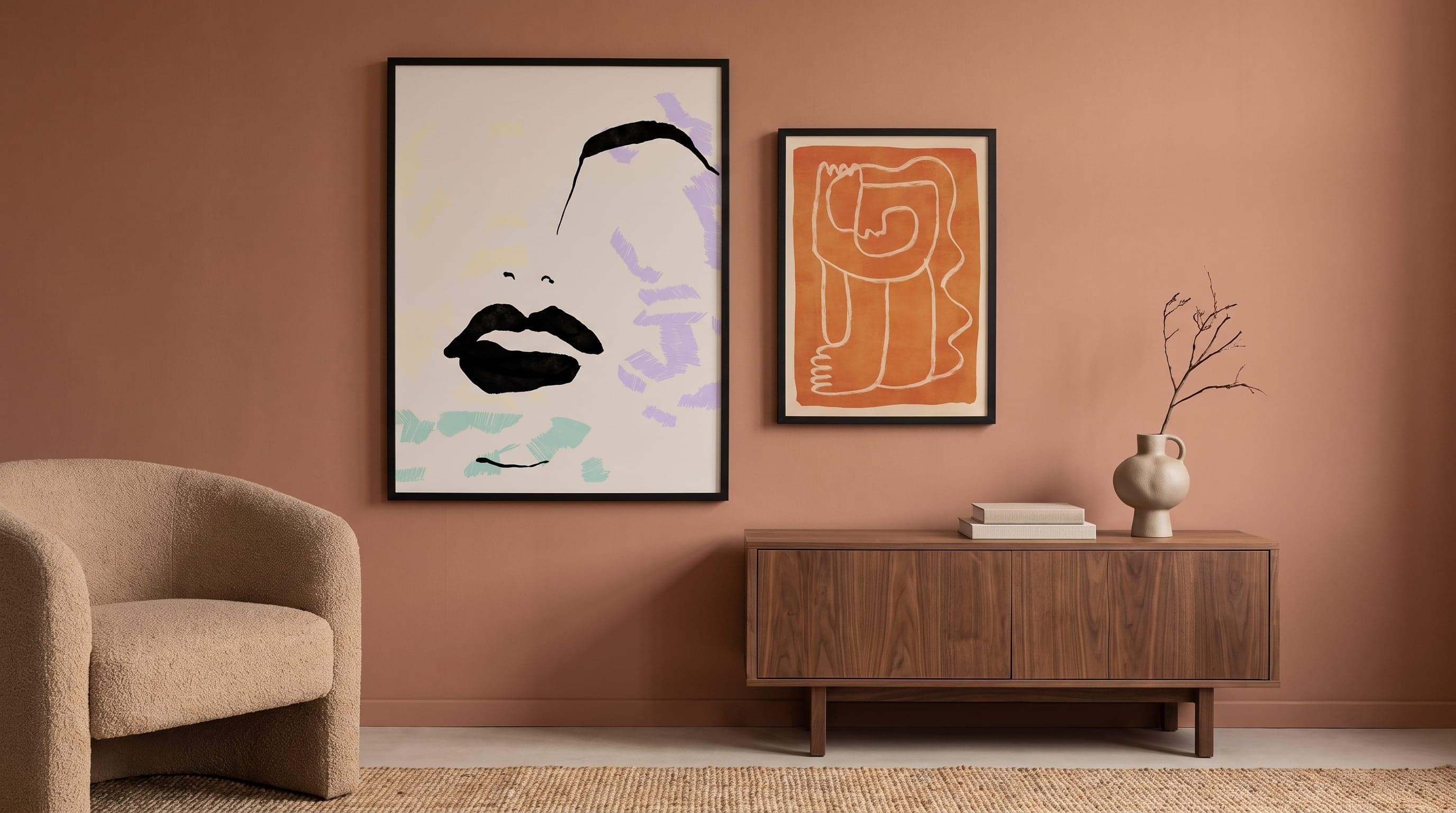 Warm minimalist living room with two graphic portrait prints in varied sizes on a terracotta wall