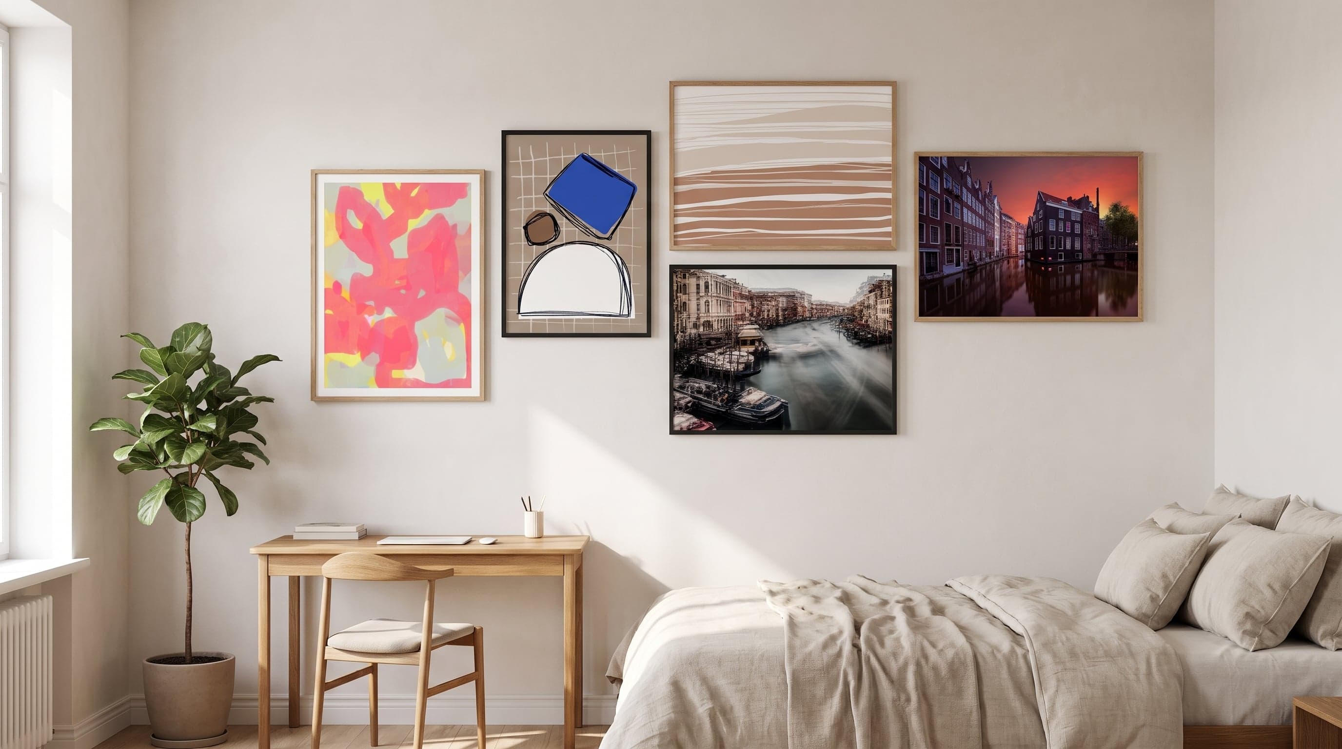 Gallery wall with five different-sized art prints above a bed and desk in a first apartment.