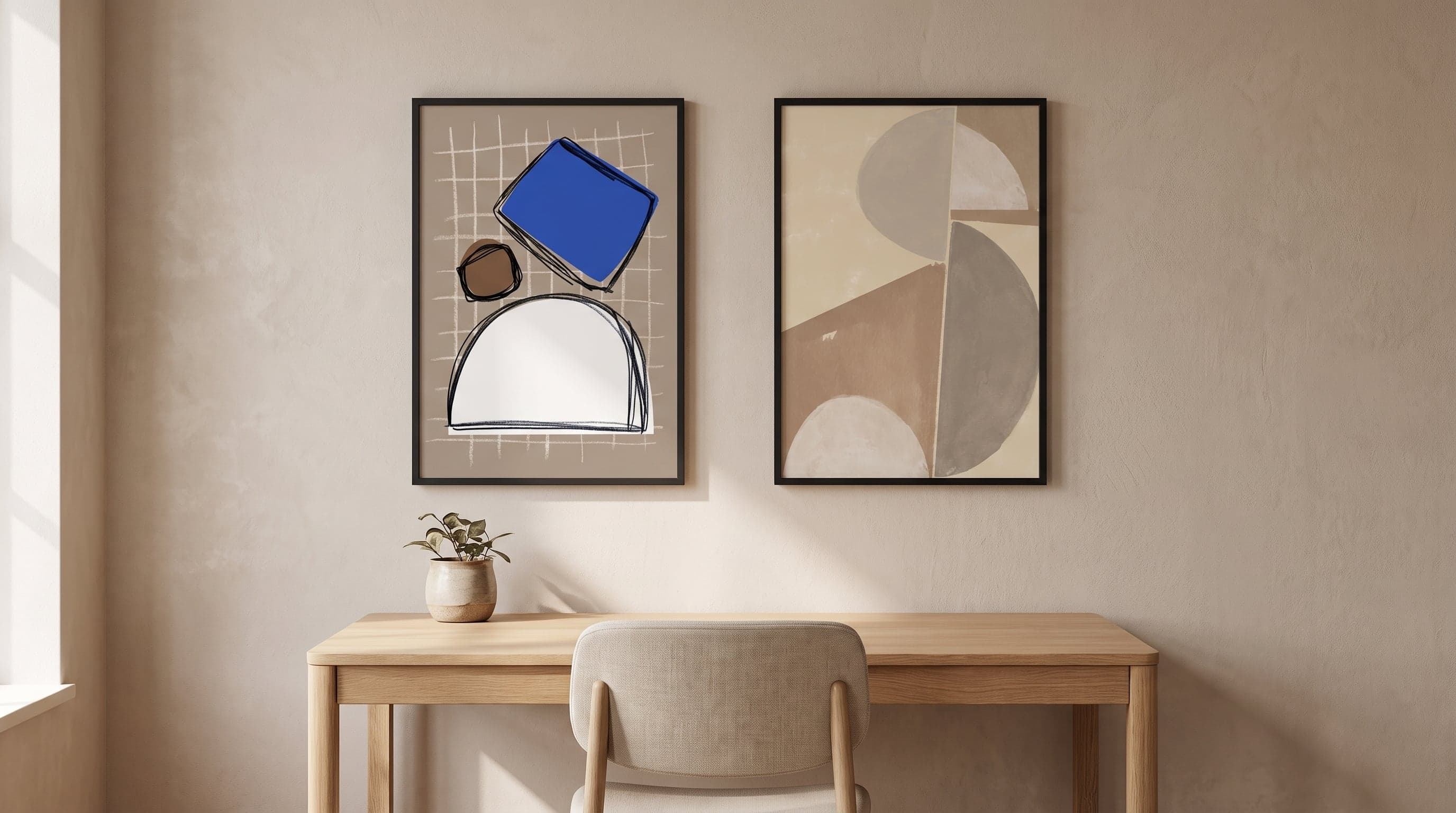 Calm home office with two abstract art prints in black frames above the desk.